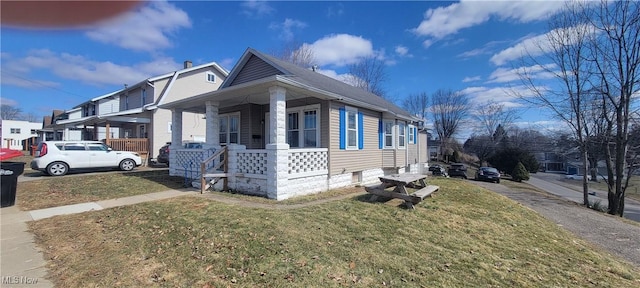 view of property exterior featuring a porch and a lawn