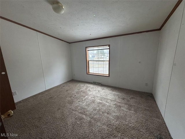 spare room with carpet floors, ornamental molding, and a textured ceiling