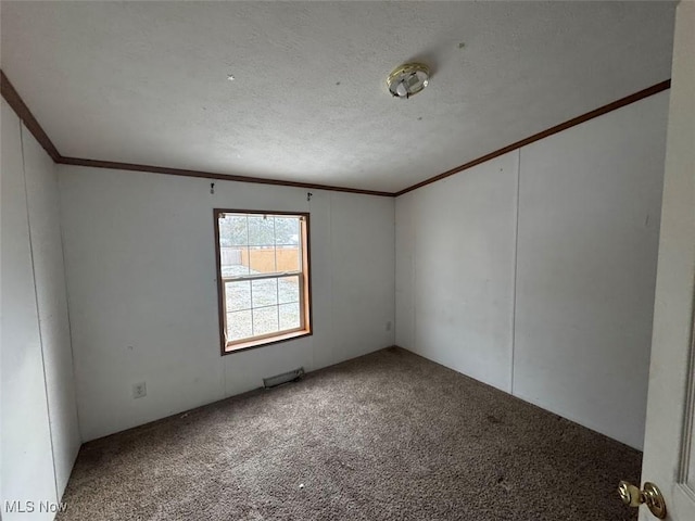 carpeted spare room featuring ornamental molding and a textured ceiling