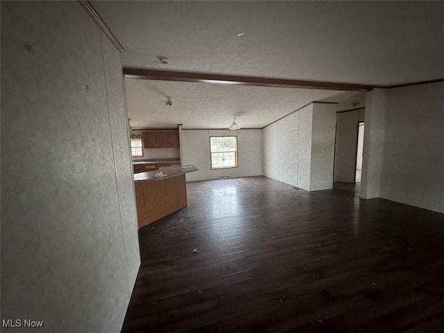 interior space with dark wood-type flooring and beam ceiling