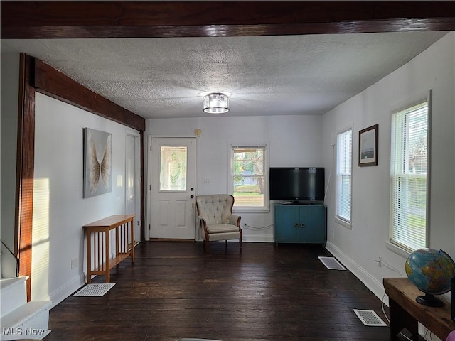 entryway featuring baseboards, a textured ceiling, visible vents, and dark wood-type flooring