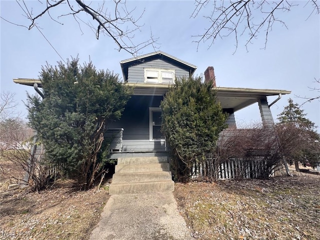 view of property hidden behind natural elements featuring a porch