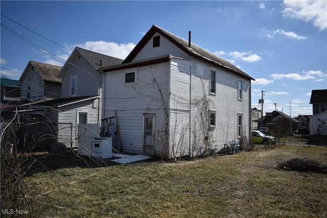 back of house with a lawn