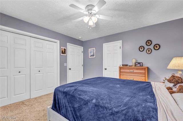 bedroom with carpet floors, a closet, ceiling fan, and a textured ceiling