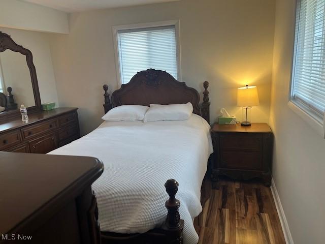 bedroom with dark wood finished floors and baseboards