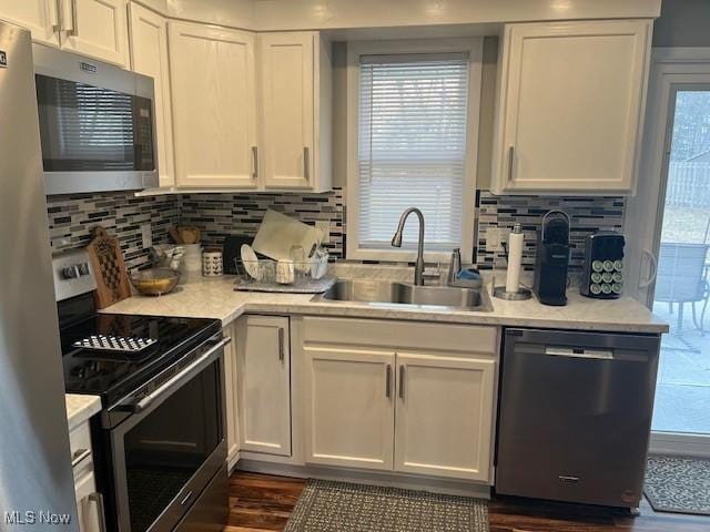 kitchen with white cabinetry, appliances with stainless steel finishes, light countertops, and a sink