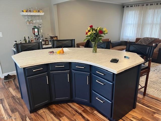 kitchen featuring a breakfast bar, dark wood finished floors, and open floor plan