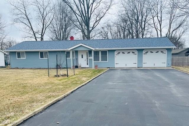 ranch-style house featuring an attached garage, driveway, a chimney, and a front yard