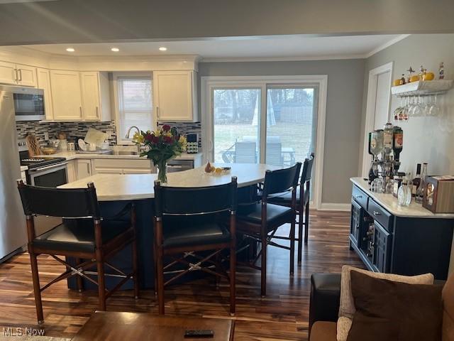 kitchen featuring white cabinetry, stainless steel appliances, a sink, and light countertops