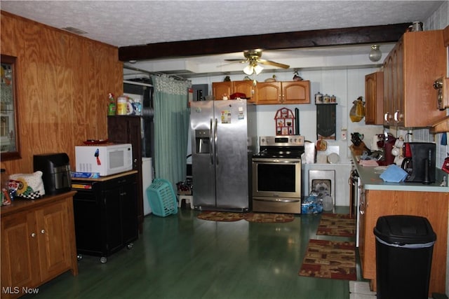 kitchen with light wood finished floors, appliances with stainless steel finishes, brown cabinets, a textured ceiling, and beam ceiling