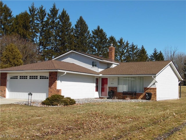 view of front of home featuring a garage, brick siding, driveway, a chimney, and a front yard