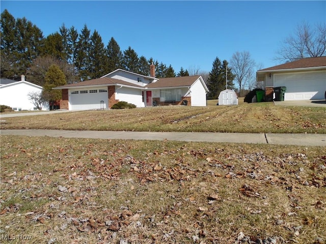 exterior space with a storage shed, an outbuilding, an attached garage, a front lawn, and brick siding