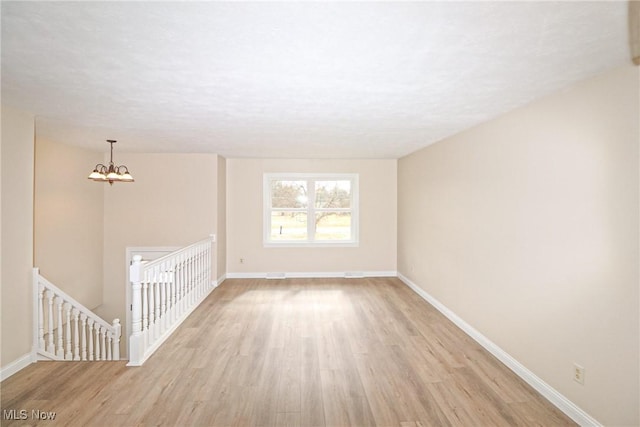 757 Eastern Rd, Doylestown, OH 44230 - unfurnished living room with a chandelier, light wood-type flooring, and baseboards