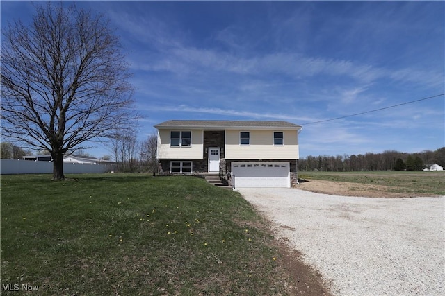 757 Eastern Rd, Doylestown, OH 44230 - bi-level home featuring fence, driveway, stone siding, a front yard, and a garage