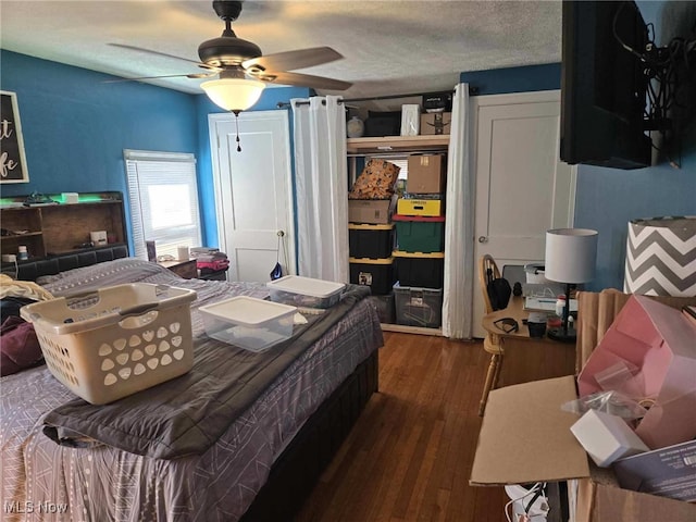 bedroom with dark wood-style floors, a textured ceiling, and a ceiling fan