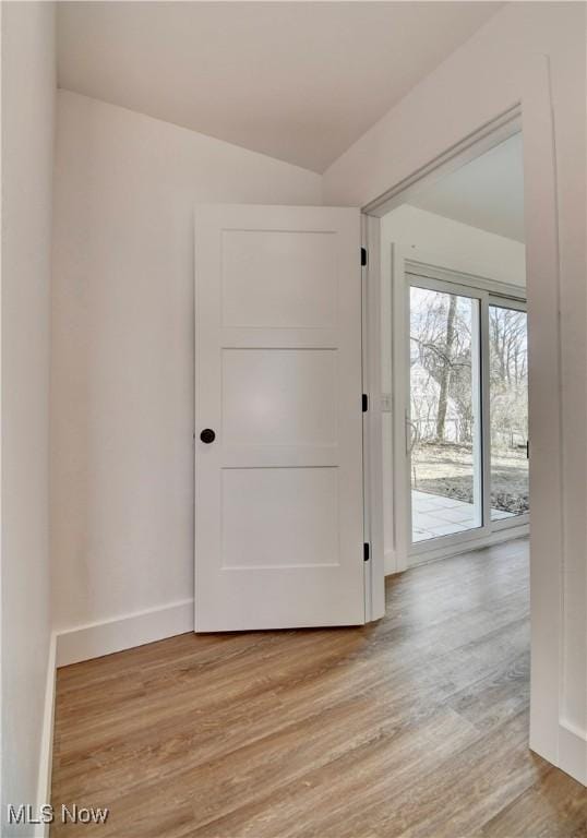 foyer entrance with light wood-style flooring and baseboards