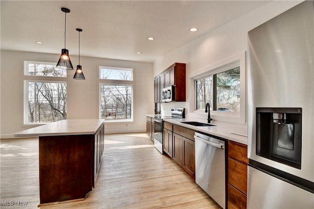 kitchen with light countertops, appliances with stainless steel finishes, plenty of natural light, and a sink