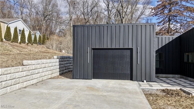 view of outdoor structure with a garage and concrete driveway