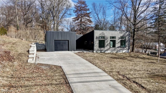 exterior space featuring an outbuilding, concrete driveway, and an attached garage