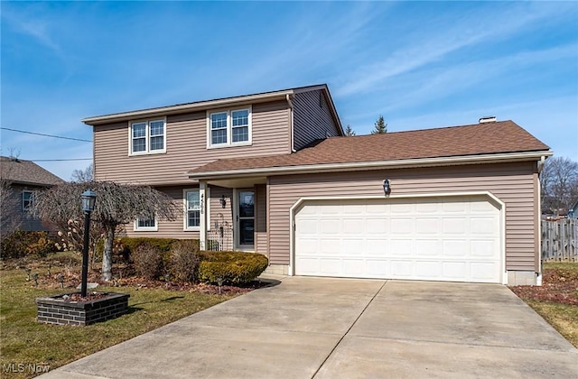 traditional-style house featuring a shingled roof, driveway, an attached garage, and fence