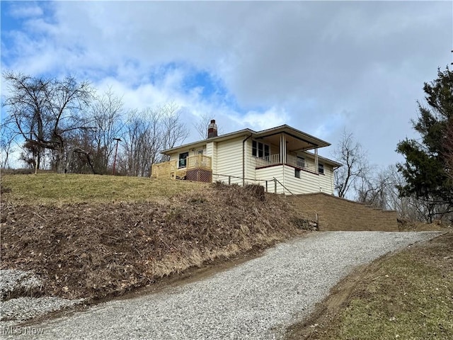 view of side of property with driveway and a chimney