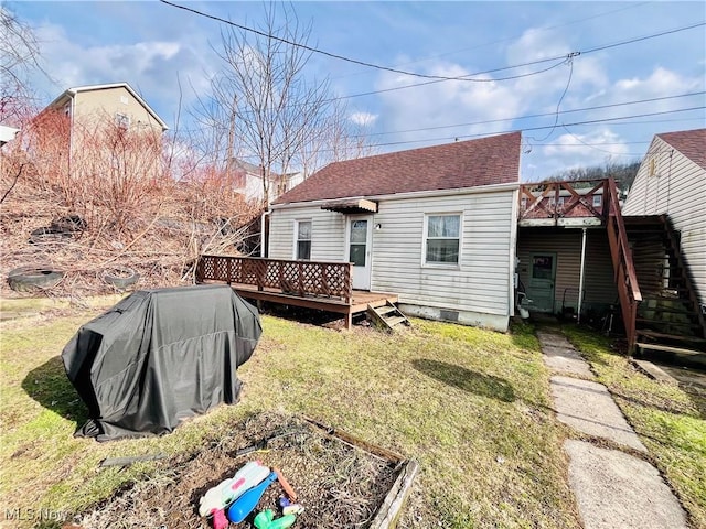 back of house with roof with shingles, a lawn, stairway, and a wooden deck