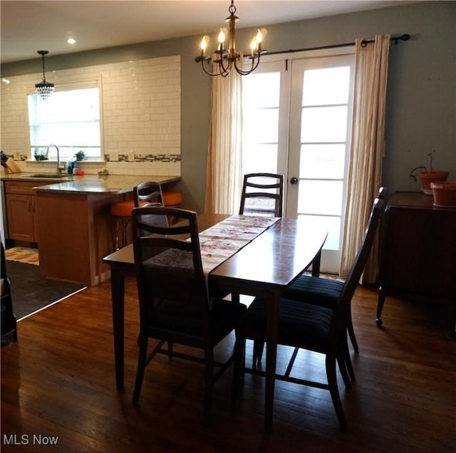 dining room with dark wood-style flooring, recessed lighting, and an inviting chandelier