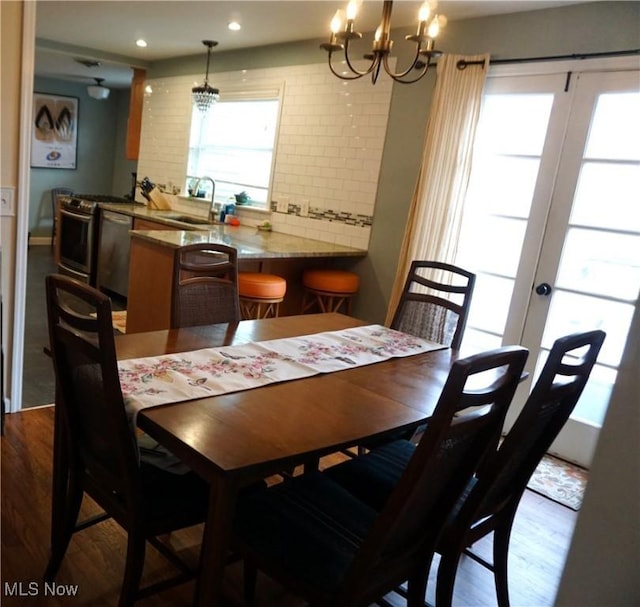 dining room featuring a chandelier, recessed lighting, french doors, and wood finished floors