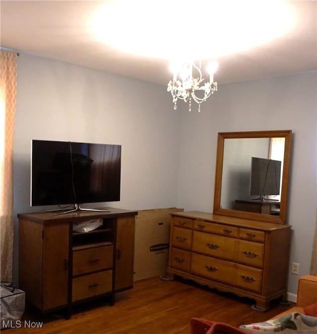 living area with wood finished floors and a notable chandelier