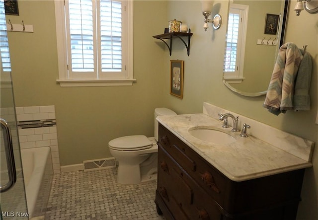 full bathroom featuring visible vents, baseboards, toilet, a washtub, and vanity