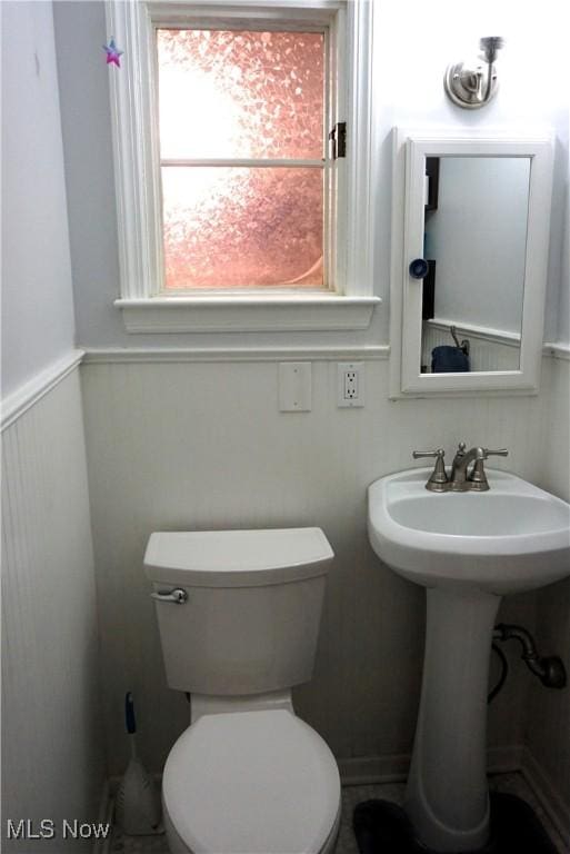 bathroom with wainscoting and toilet