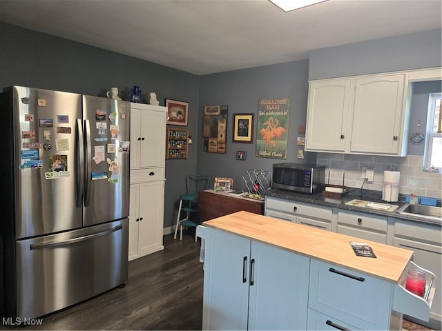 kitchen with dark wood-style floors, stainless steel appliances, wood counters, and white cabinets