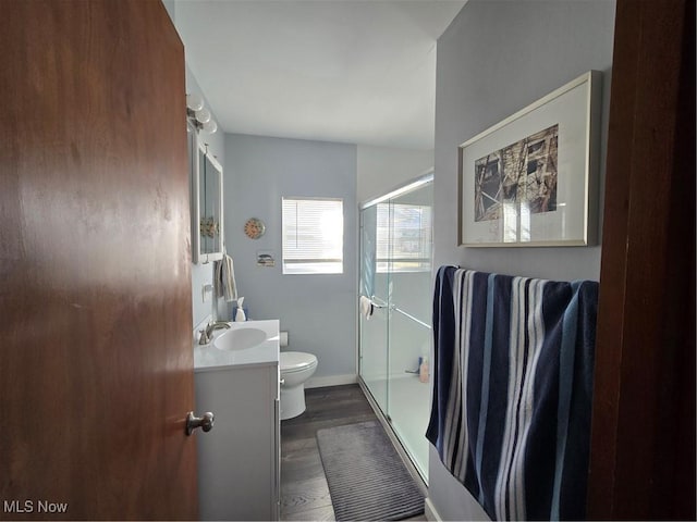 bathroom with toilet, baseboards, wood finished floors, and vanity