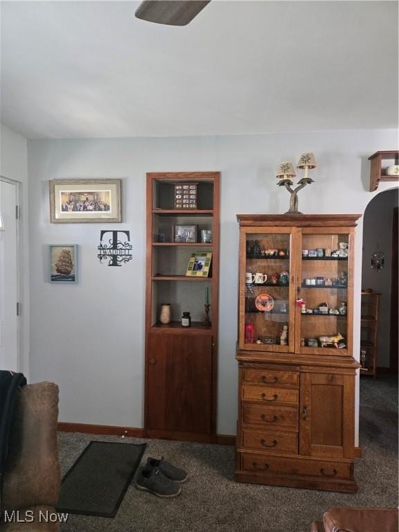 interior space with arched walkways, carpet flooring, and baseboards