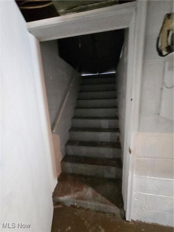 staircase with concrete block wall