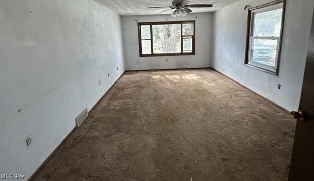 empty room with ceiling fan and visible vents