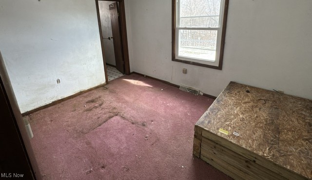 unfurnished room featuring carpet and visible vents