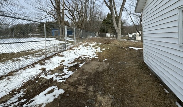 snowy yard featuring fence