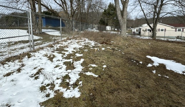 snowy yard with fence