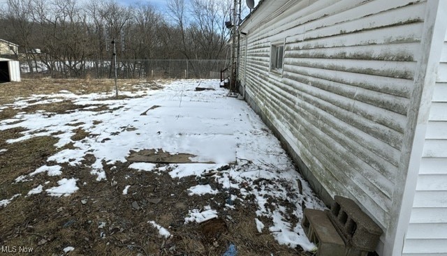 snowy yard featuring fence