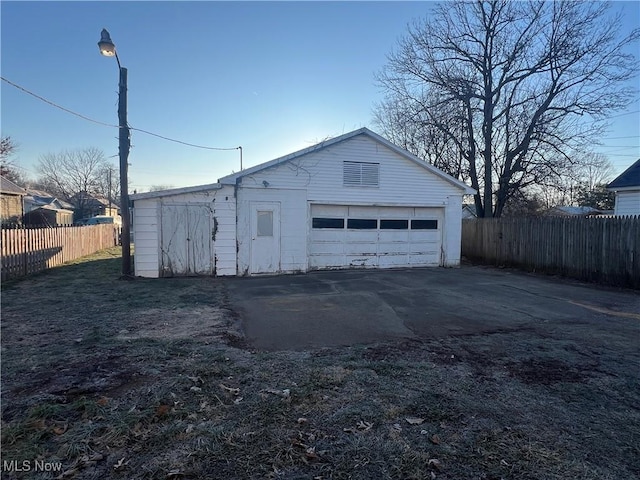 detached garage featuring fence