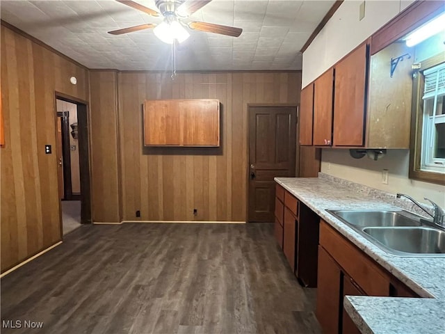 kitchen with brown cabinetry, a sink, and wooden walls