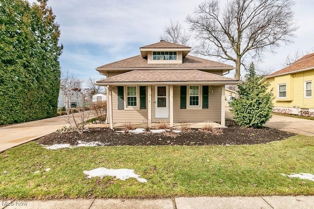 bungalow-style house with driveway, a front lawn, and a porch