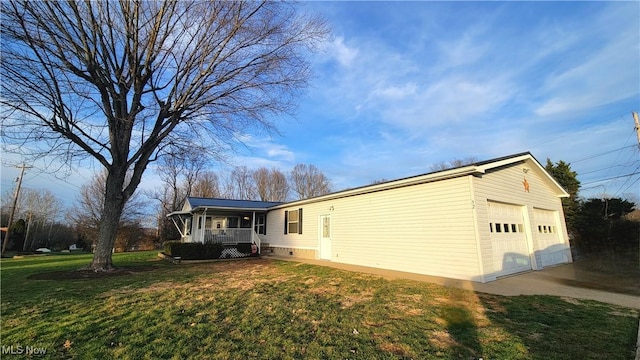 view of side of property with a garage, a porch, and a lawn