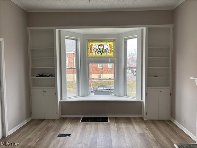 interior space featuring baseboards, visible vents, and wood finished floors