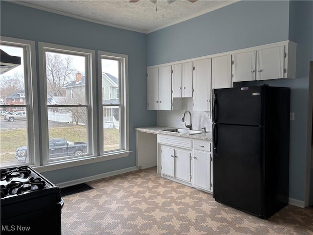 kitchen featuring visible vents, white cabinetry, a sink, a textured ceiling, and black appliances