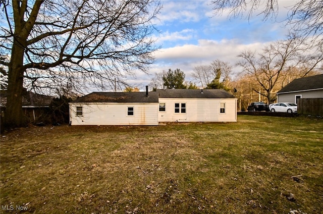 back of property with a yard and fence