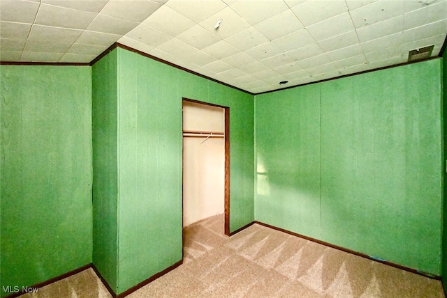 unfurnished bedroom featuring a closet, carpet flooring, and crown molding