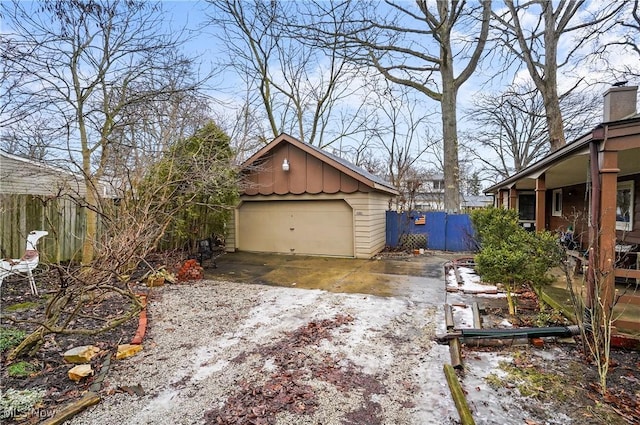 exterior space with a garage, fence, board and batten siding, and an outdoor structure