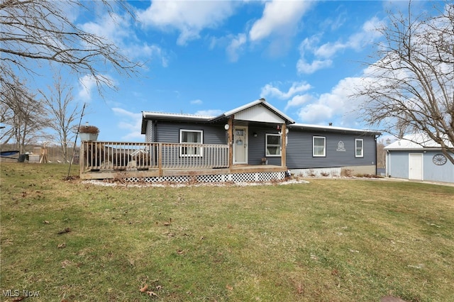 single story home with an outbuilding, a wooden deck, and a front lawn